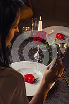 Valentines day, heart cake on white plate, romantic evening and gift, pretty woman with rose in hand.