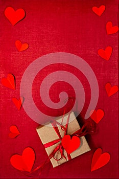 Valentines day hearts, gift box on greeting card on old red fabric background