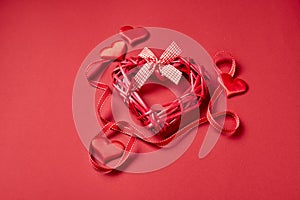 Valentines day hearts and ribbon on red background.