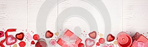 Valentines Day long banner border with red gifts and decorations over a white wood background with copy space