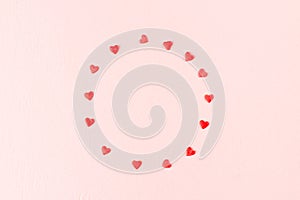 Valentines day love concept. Frame of red hearts on pink background.