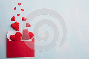 Valentines day and love concept. Red hearts splash out from red pink letter cover on blue sky wooden background