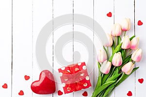 Valentines day and love concept. Two handmade red hearts with tulips and gift box on white wooden