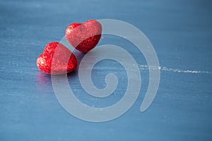Valentines day and love concept. Two red hearts on gray wooden background.