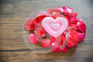 Valentines day love heart concept / Pile of roses petals with pink heart decorated on wooden table