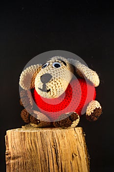 Valentines day plush toy in the shape of a handmade dog with a red heart on his belly as a symbol of love