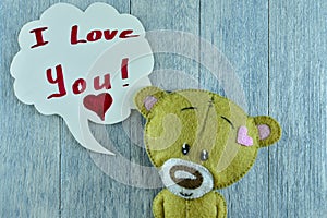 Valentines Day postcard. Teddy bear on wooden background.