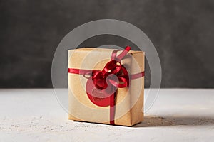 Valentines day present gift box wrapped in brown craft paper with red ribbon and red tag