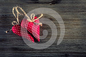 Valentines day. Red cloth handmade hearts on wooden background