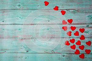 Valentines day red hearts on green/teal blue wooden background