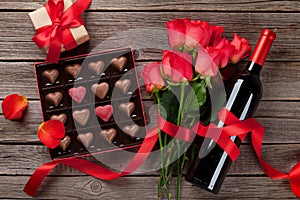 Valentines day with red roses, wine bottle and chocolate box