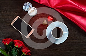 Valentines Day romantic background with wedding ring, rose flowers, smartphone, cup of coffee and chocolate candy