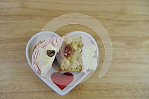Valentines day romantic cup cake in pink and white with strawberry jam center and love heart decorations