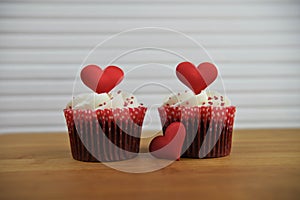 Valentines day romantic cup cakes in strawberry and cream flavor with red love heart decorations on top