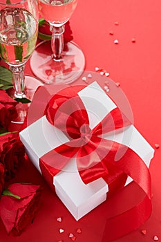 Valentines Day or Romantic dinner concept. Romantic table setting, silverware, wine glasses, gift box, roses and symbol of love re