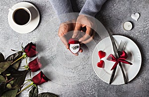 Valentines day romantic dinner table setting man hand holding engagement ring