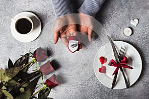 Valentines day romantic dinner table setting man hand holding engagement ring