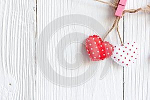 Valentines Day. Sewed pillow hearts row border on red and white clothespins at rustic white wood planks. Happy lovers day card moc