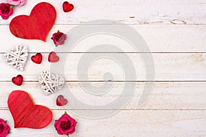 Valentines Day side border of hearts, flowers and decor against white wood