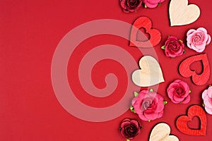 Valentines Day side border of wooden hearts and roses on a red banner background