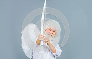 Valentines day. Smiling bearded man in angel costume aiming with bow. Male Valentine angel in white wig shoot arrow of