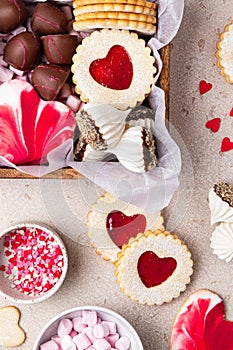 Valentines Day sweets and cookies in wooden box. Chocolate, candy, meringue, marshmallow, linzer cookies, gingerbread.