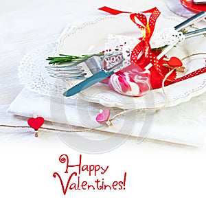 Valentines day table setting with plate, knife, fork, red ribbon