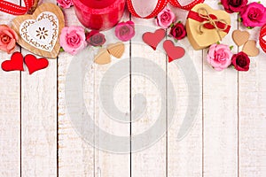 Valentines Day top border of hearts, flowers, gifts and decor on white wood