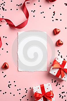 Valentines Day vertical banner template with blank paper card, gift boxes, red ribbon and hearts on pink background. Suitable for