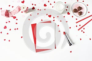 Valentines day, wedding still life scene. Candle, paper confetti, chocolate hearts, lipstick and blank greeting card