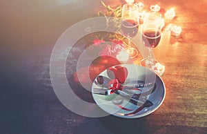 Valentines dinner romantic love concept Romantic table setting decorated with Red heart fork spoon on plate and couple champagne