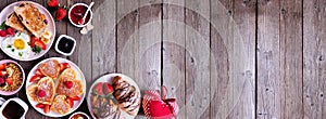 Valentines or Mothers Day breakfast corner border on a dark wood banner background with heart shaped pancakes, eggs