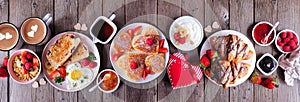Valentines or Mothers Day breakfast table scene on a dark wood banner background with heart shaped pancakes, eggs