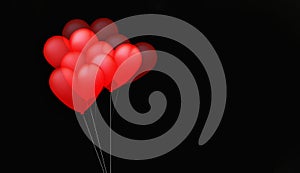 Valentines motive with moving red balloons on black background with copy space. Six balloons on strings photo