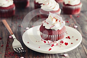 Valentines red velvet cupcakes on a rustic wooden table