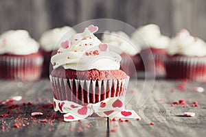 Valentines red velvet cupcakes on a rustic wooden table