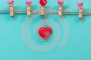 Valentineâ€™s Day. Sewed pillow hearts row border on red clothespins at rustic white wood planks.