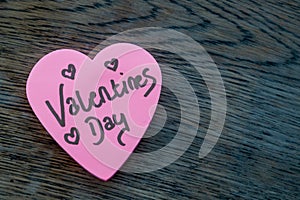 Valentineâ€™s Day wrote text on pink love heart with drawn hearts. On rustic wooden background. Love Valentines concept