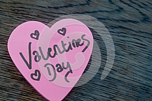 Valentineâ€™s Day wrote text on pink love heart with drawn hearts. On rustic wooden background. Love Valentines concept