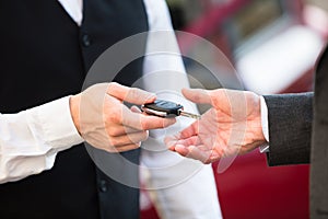 Valet Giving Car Key To Businessperson