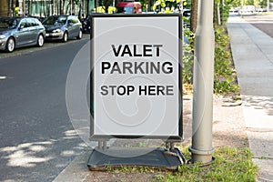 Valet parking sign on board by street