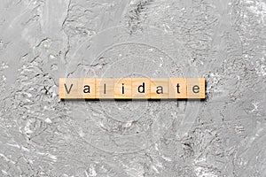 VALIDATE word written on wood block. VALIDATE text on cement table for your desing, concept photo