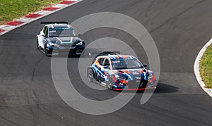 Electric cars battle in action racing on asphalt track, Cupra and Hyundai