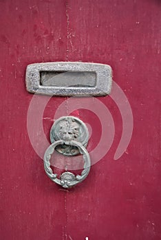 Valletta, Malta, August 2019. Fragment of an old red door with a vintage doorknob.