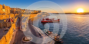 Valletta, Malta - Panoramic skyline view of Valletta and the Grand Harbor with beautiful sunrise, ships