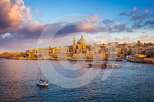 Valletta, Malta - Sail boats at the walls of Valletta with Saint Paul`s Cathedral and beautiful sky and clouds