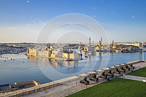 Valletta, Malta - Skyline view of the Grand Harbour and Saluting Battery cannons with Senglea and docks at background