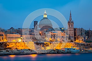 Valletta seafront skyline view as seen from Sliema, Malta. St Paul's Cathedral after sunset