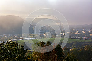Údolí s panoramatem města v pozadí za zamračeného dne. Banská Bystrica, Slovensko.