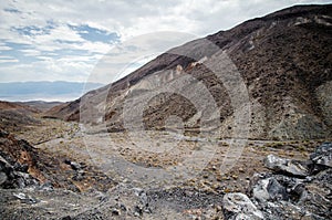 Valley and a desert wash filled with rocks, sand and sagebrush in Death Valley National Park in California